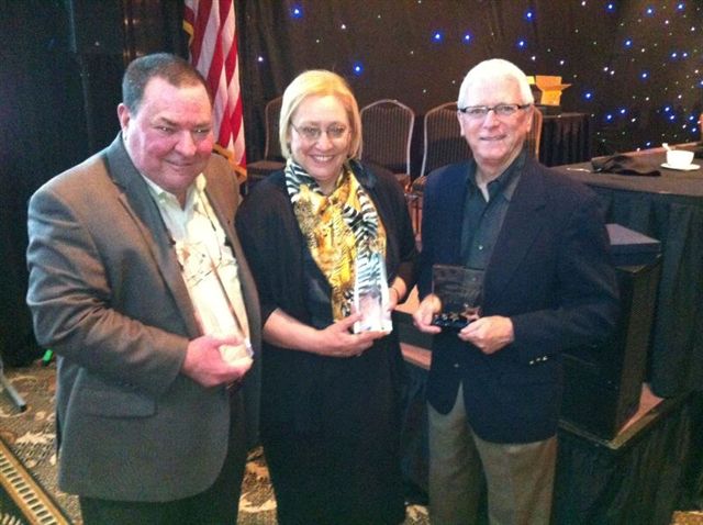 Vicki Hidde standing with two men in suits receiving 2013 Small Business Award from Tulsa Chamber of Commerce